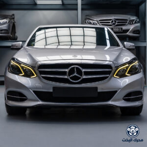 واجهة مرسيدس E250 فضية موديل 2014 داخل مستودع مع شعار محرك اليخت