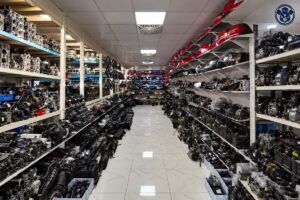 ممر مستودع بين رفوف محركات ومصابيح وقطع سيارات مع امتداد توضيحي للخلفية