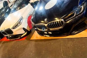 واجهتا BMW داكنة وبيضاء متجاورتان على قواعد داخل معرض قطع